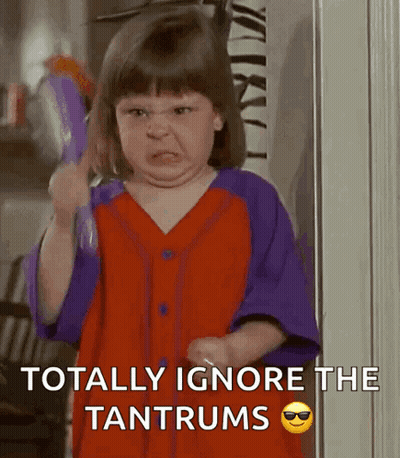 A Little Girl Is Making An Angry Face While Holding A Brush And The Words Totally Ignore The Tantrums GIF