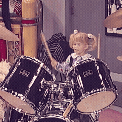 A Little Girl Is Playing The Drums With A Pearl Drum Set GIF