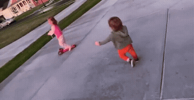 A Little Girl Is Riding A Scooter Next To A Little Boy On A Sidewalk . GIF