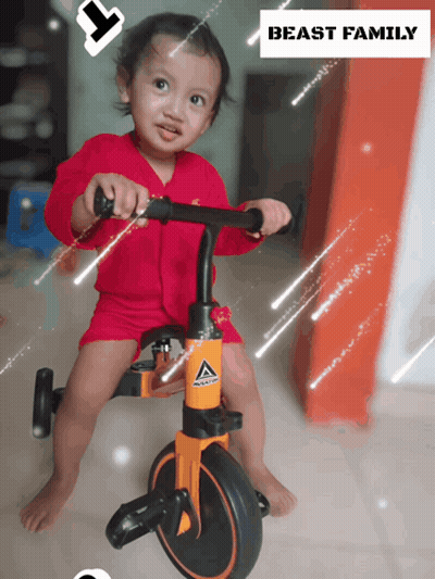 A Little Girl Is Riding A Tricycle With The Words Beast Family Above Her GIF
