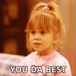 A Little Girl Is Saying `` You Da Best '' While Wearing A Pink Shirt . GIF