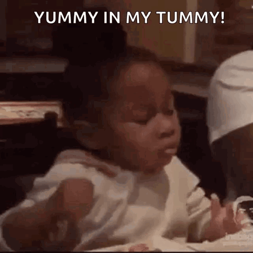A Little Girl Is Sitting At A Table Eating Ice Cream . GIF