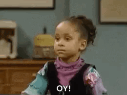 A Little Girl Is Sitting At A Table Making A Funny Face . GIF