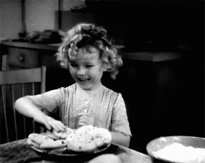 A Little Girl Is Sitting At A Table With A Bowl Of Flour And A Plate Of Food . GIF