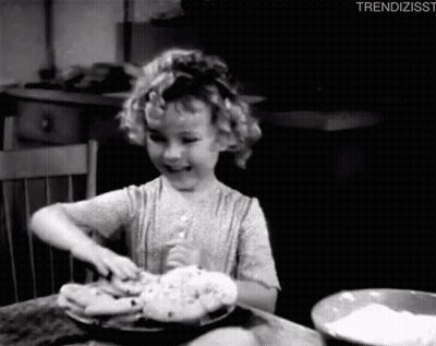 A Little Girl Is Sitting At A Table With A Bowl Of Flour And A Plate Of Food . GIF