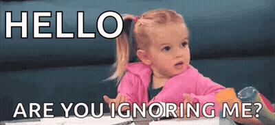 A Little Girl Is Sitting At A Table With The Words `` Hello Are You Ignoring Me ? '' Written On It . GIF