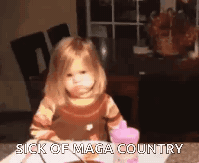 A Little Girl Is Sitting At A Table With The Words `` Sick Of Maga Country '' Written On The Table . GIF