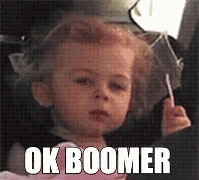 A Little Girl Is Sitting In A Car Seat Holding A Lollipop And Making A Face . GIF