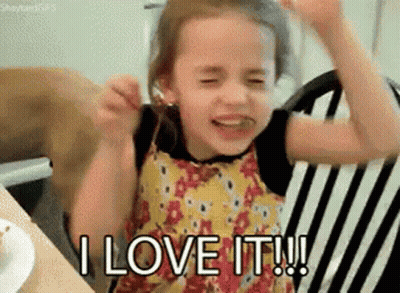 A Little Girl Is Sitting In A Chair With Her Arms In The Air And Saying I Love It . GIF
