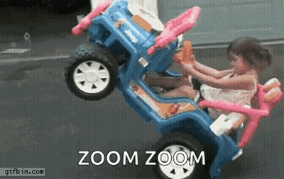 A Little Girl Is Sitting In A Toy Car With The Words Zoom Zoom Written On The Bottom . GIF