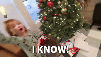 A Little Girl Is Sitting In Front Of A Christmas Tree With The Words I Know Above Her GIF