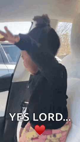 A Little Girl Is Sitting In The Back Seat Of A Car Saying Yes Lord GIF
