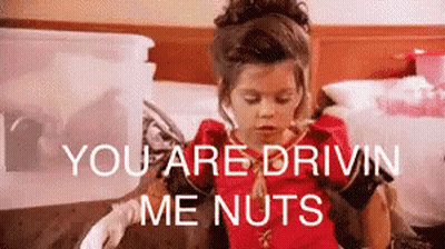A Little Girl Is Sitting On A Bed With The Words `` You Are Drivin Me Nuts '' Behind Her . GIF