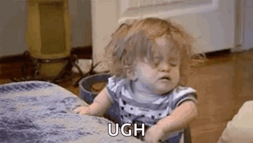 A Little Girl Is Sitting On A Couch And Making A Face . GIF