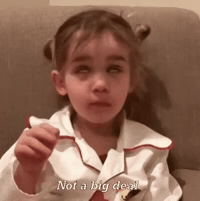 A Little Girl Is Sitting On A Couch And Making A Funny Face While Holding Something In Her Hand . GIF