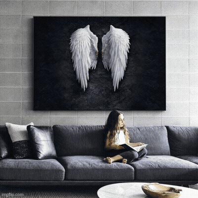 A Little Girl Is Sitting On A Couch Reading A Book Under A Painting Of Angel Wings GIF