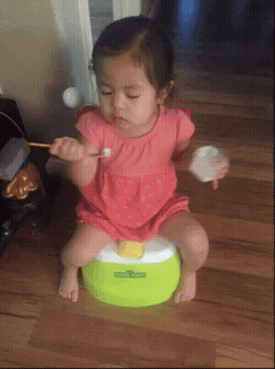 A Little Girl Is Sitting On A Green Potty With Sesame Street Written On It GIF