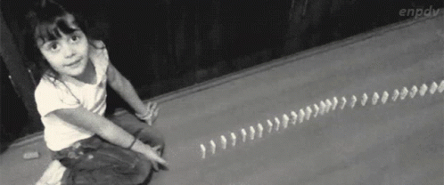 A Little Girl Is Sitting On The Floor Playing With Dominoes GIF