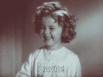 A Little Girl Is Smiling And Saying David In A Black And White Photo GIF