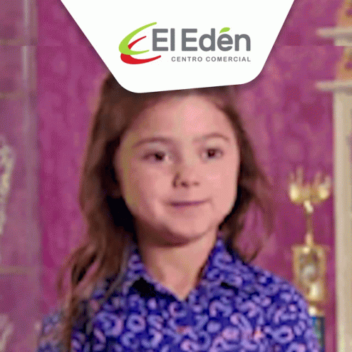 A Little Girl Is Smiling In Front Of A El Eden Centro Comercial Logo GIF