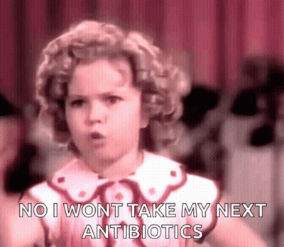 A Little Girl Is Standing In Front Of A Red Curtain And Says `` No I Won T Take My Next Antibiotics '' . GIF