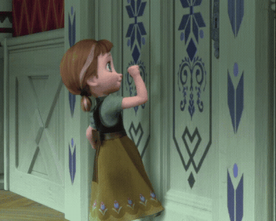 A Little Girl Is Standing In Front Of A Wall With A Geometric Design GIF