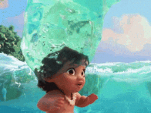 A Little Girl Is Standing In The Ocean Holding A Giant Bubble . GIF