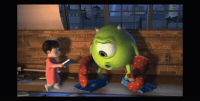 A Little Girl Is Standing Next To A Green Monster GIF