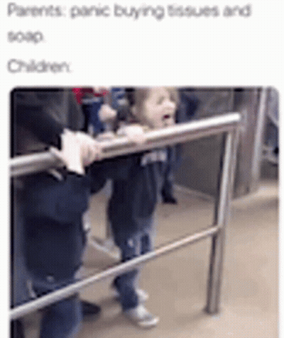 A Little Girl Is Standing Next To A Railing On A Subway Train . GIF