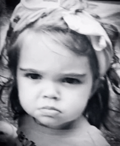 A Little Girl Is Wearing A Headband And Making A Funny Face GIF