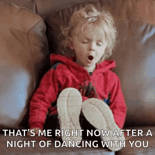 A Little Girl Is Yawning While Sitting On A Couch With Her Legs Crossed GIF