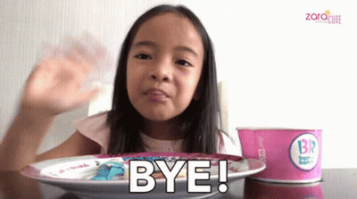 A Little Girl Sitting At A Table With A Plate Of Food And A Cup Of Ice Cream That Says Br On It GIF