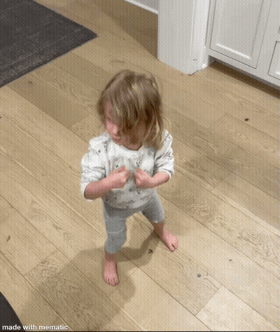 a little girl standing on a wooden floor with the words made with mematic at the bottom