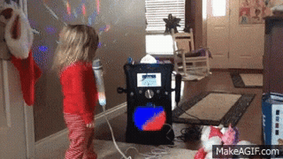 A Little Girl Stands In Front Of A Karaoke Machine GIF
