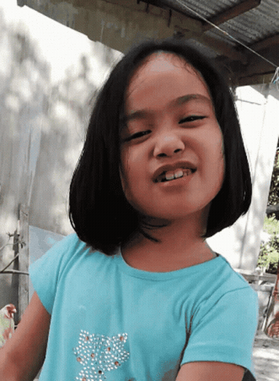 A Little Girl Wearing A Blue Shirt With A Butterfly On It GIF