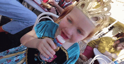 A Little Girl Wearing A Crown Holds A Bottle GIF