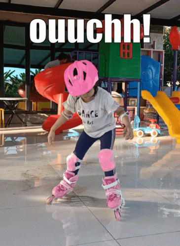 A Little Girl Wearing A Pink Helmet Is Rollerblading With The Words Ouuchh Behind Her GIF