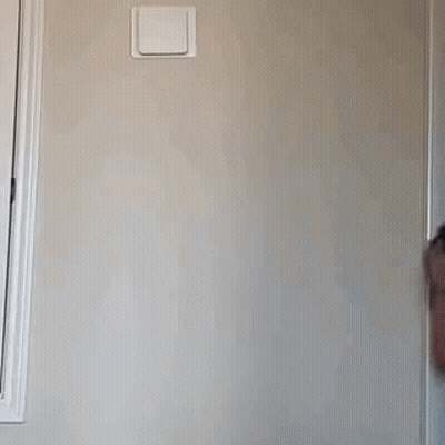 A Little Girl Wearing A Rainbow Tank Top Is Standing In Front Of A Wall GIF