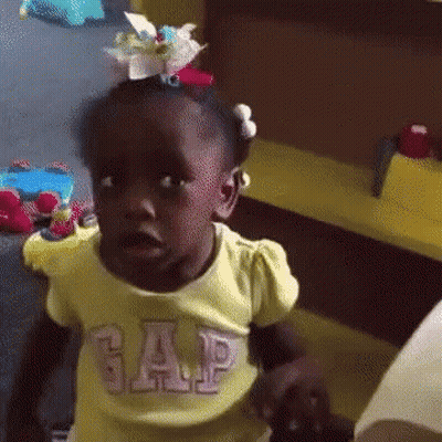 A Little Girl Wearing A Yellow Gap Shirt Is Making A Funny Face GIF