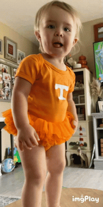 A Little Girl Wearing An Orange T-Shirt And Orange Tutu GIF