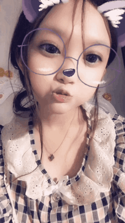 A Little Girl Wearing Glasses And A Plaid Shirt GIF