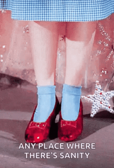 A Little Girl Wearing Red Shoes And Blue Socks Is Standing On A Sidewalk . GIF