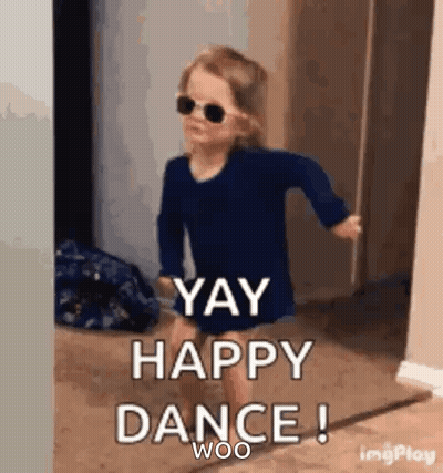 a little girl wearing sunglasses and a blue shirt is dancing in a hallway .