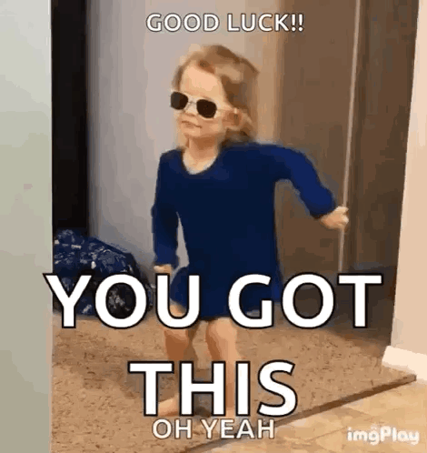 A Little Girl Wearing Sunglasses And A Blue Shirt Is Walking Through A Doorway . GIF