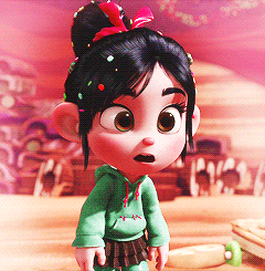 A Little Girl With A Bun And Sprinkles On Her Hair Is Wearing A Green Hoodie GIF