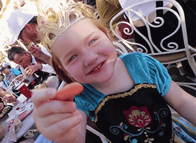 A Little Girl With A Crown On Her Head Is Holding A Carrot GIF