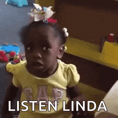 A Little Girl With A Flower In Her Hair Is Sitting At A Table And Says Listen Linda . GIF