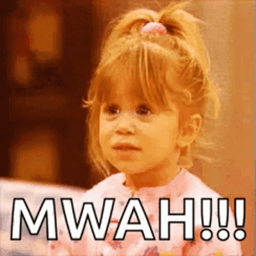 A Little Girl With A Ponytail Is Making A Funny Face And Saying Mwah ! GIF