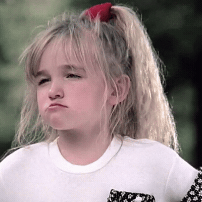 A Little Girl With A Red Bow In Her Hair Is Making A Face GIF