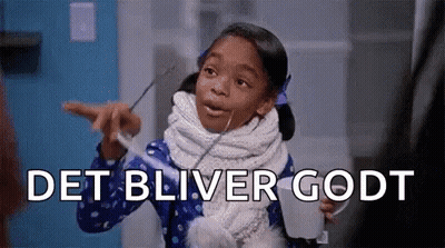 A Little Girl With A Scarf Around Her Neck Is Holding A Cup And Pointing At The Camera . GIF